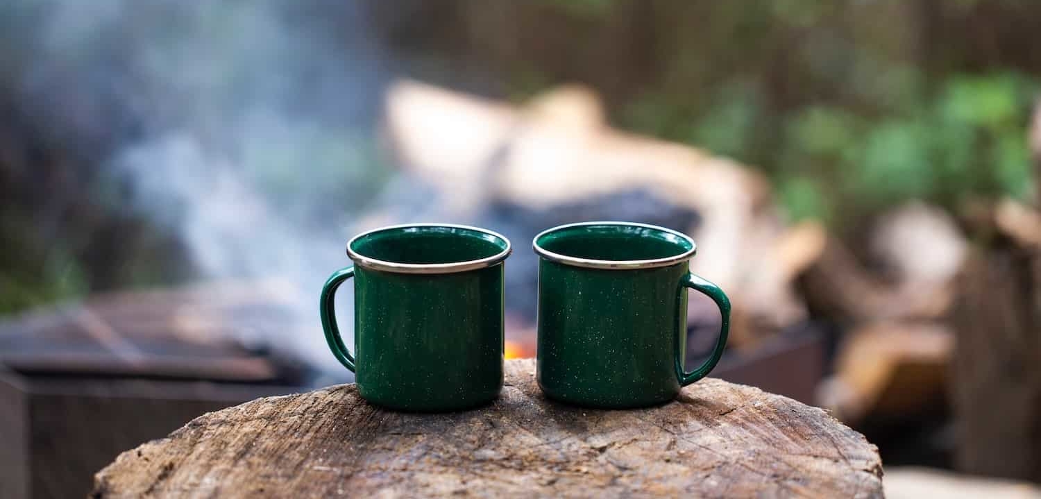 https://www.outdoorsynomad.com/wp-content/uploads/2022/12/coffee-makers-for-campers-coffee-mug-on-tree-stump-e1671156727283.jpeg